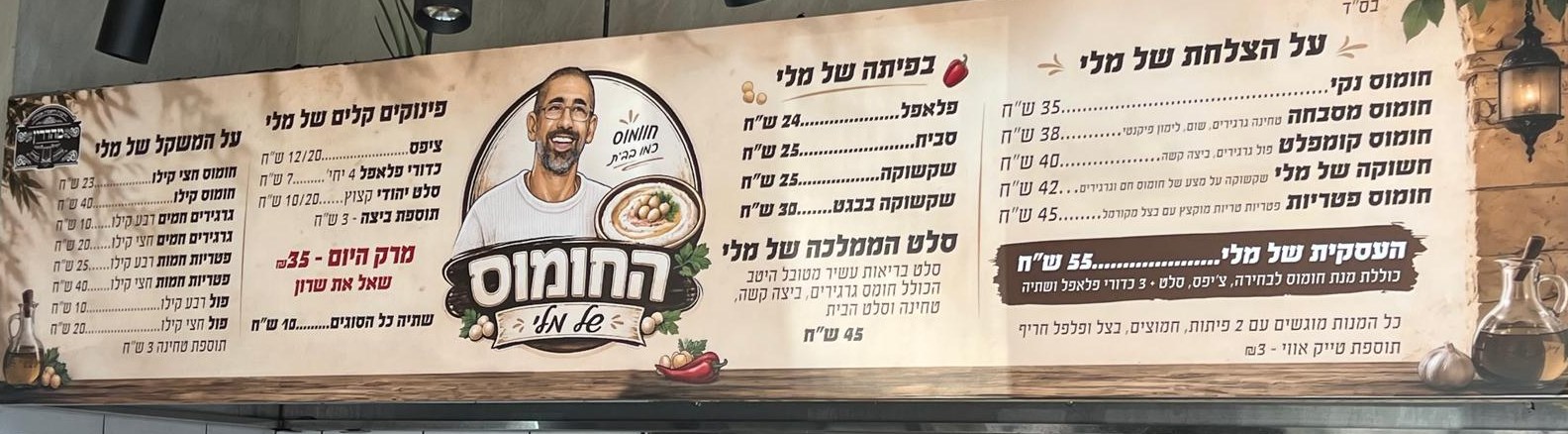 התפריט המלא של החומוס של מלי על השלט במסעדה — מנות, תוספות ומחירים